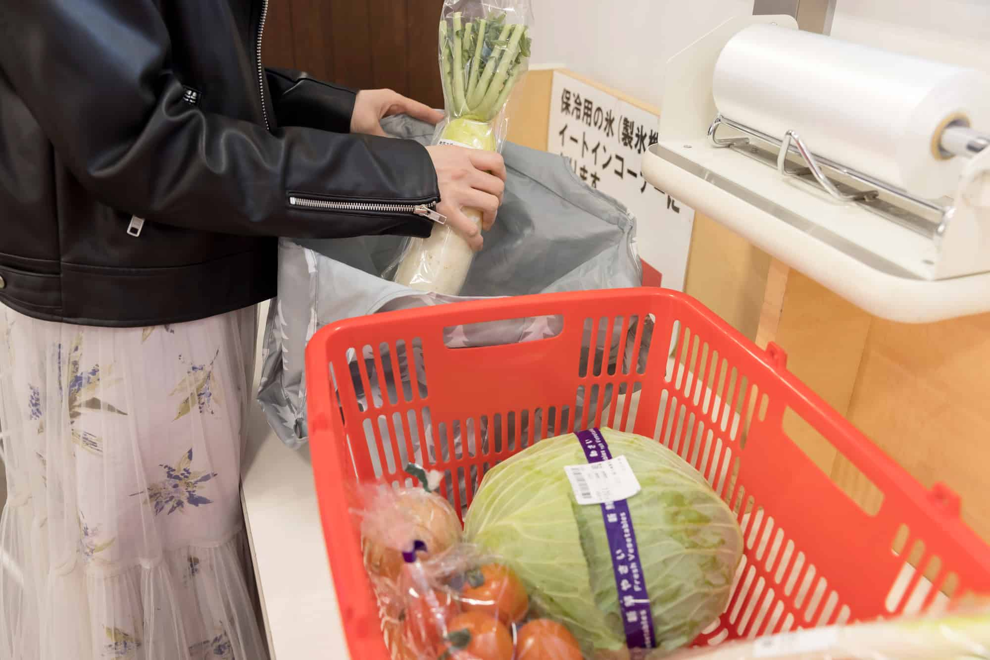 ビニール袋に食品を入れる主婦